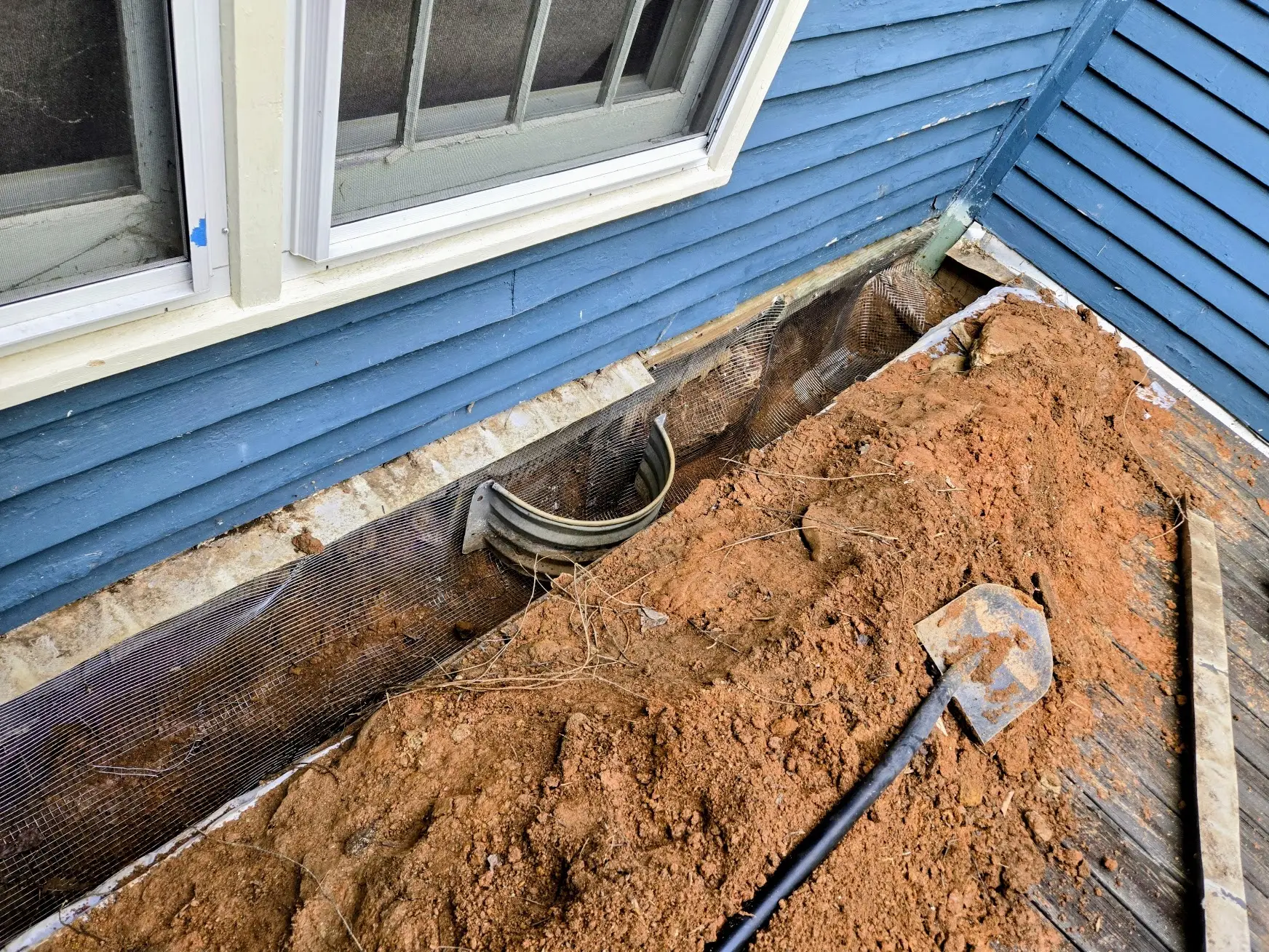 Stainless steel mesh crawlspace exclusion barrier trenched below grade